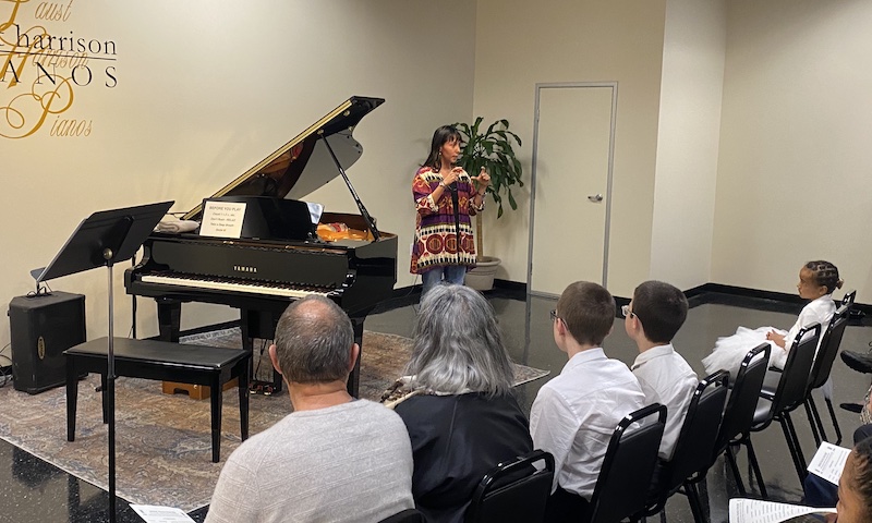 Sales consultant Margaret Cassetto introduces the store and piano at the Spring 2024 Student Concert.